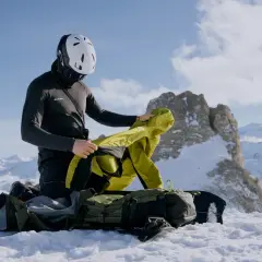 Bergsteiger im Schnee passt sich dem Zwiebelprinzip Kleidung an, um sich vor Kälte zu schützen.