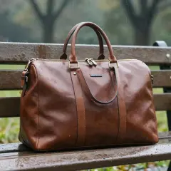 Braune Ledertasche auf einer nassen Parkbank im Regen. Das Leder ist wasserdicht und schützt den Inhalt.