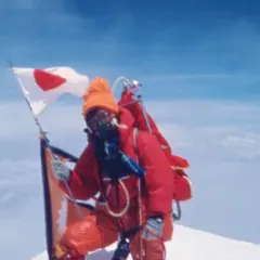 Junko Tabei mit japanischer Flagge auf dem Gipfel des Mount Everest.