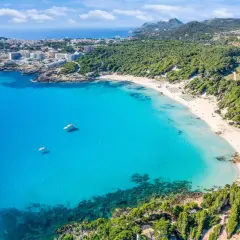 Traumhafte Bucht mit türkisfarbenem Wasser, weißem Sandstrand und Pinienwäldern. Ideal für einen fernwanderweg auf Mallorca.