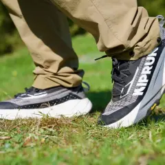 Ein Paar moderne trailrunning schuhe mit grobem Profil auf Gras. Perfekt für jedes Abenteuer.