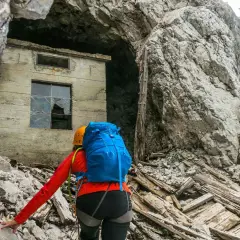 Bergsteigerin nähert sich einer Ruine am Fuße der Zugspitze, die an die Eisenzeit erinnert.