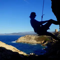 Silhouette eines Kletterers vor der Küste Korsikas. Ein Abenteuer beim Klettern auf Korsika.