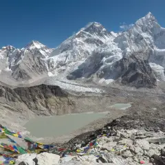 Bunte Gebetsfahnen wehen vor der majestätischen Kulisse des Kala Patthar mit dem Everest im Hintergrund.