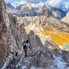 Bergsteiger auf dem Paternkofel Klettersteig, umgeben von majestätischen Dolomiten. Ein Abenteuer mit atemberaubender Aussicht.