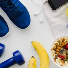 Blaue Laufschuhe, Hanteln, Obstschale, Wasserflasche und Handy – alles bereit für den Halbmarathon Essen.