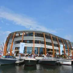 Boote liegen am Kai vor einem modernen Gebäude am NDSM Amsterdam.