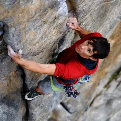 Alex Honnold klettert den El Capitan frei. Sein Blick ist konzentriert, während er sich an den Fels klammert.