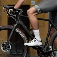 Radfahrer auf einem schwarzen Rennrad, dessen Rahmen aus Carbon gefertigt ist. Das Material Carbon, woraus besteht carbon, ist leicht und stabil.