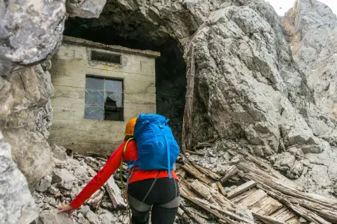 Bergsteigerin nähert sich einer Ruine am Fuße der Zugspitze, die an die Eisenzeit erinnert.