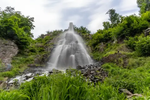 Der Trusetaler Wasserfall stürzt über Felsen in die Tiefe, umgeben von üppigem Grün.
