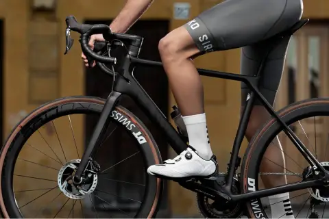 Radfahrer auf einem schwarzen Rennrad, dessen Rahmen aus Carbon gefertigt ist. Das Material Carbon, woraus besteht carbon, ist leicht und stabil.