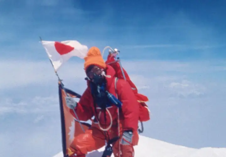 Junko Tabei mit japanischer Flagge auf dem Gipfel des Mount Everest.