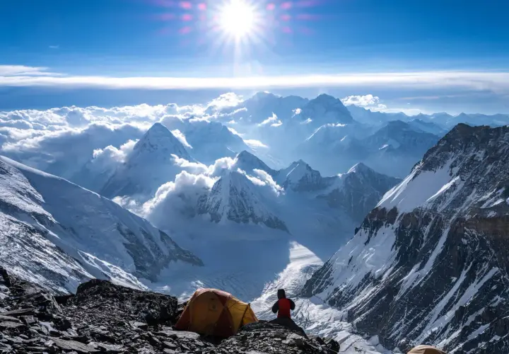 Ein Zeltlager auf dem Weg zum Gipfel des Mount Everest. Die Sonne strahlt über schneebedeckte Berge, Wolken und eisige Täler.
