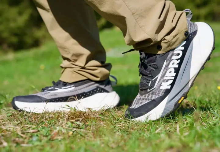 Ein Paar moderne trailrunning schuhe mit grobem Profil auf Gras. Perfekt für jedes Abenteuer.