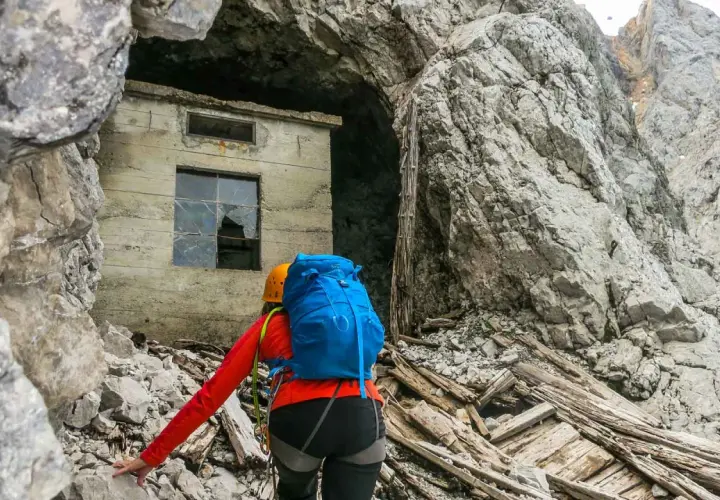 Bergsteigerin nähert sich einer Ruine am Fuße der Zugspitze, die an die Eisenzeit erinnert.