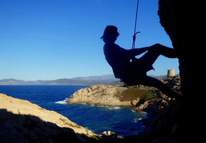 Silhouette eines Kletterers vor der Küste Korsikas. Ein Abenteuer beim Klettern auf Korsika.