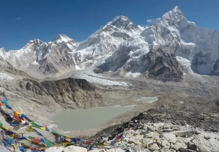 Bunte Gebetsfahnen wehen vor der majestätischen Kulisse des Kala Patthar mit dem Everest im Hintergrund.
