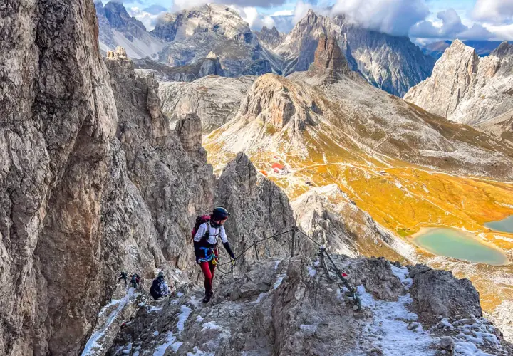 Bergsteiger auf dem Paternkofel Klettersteig, umgeben von majestätischen Dolomiten. Ein Abenteuer mit atemberaubender Aussicht.