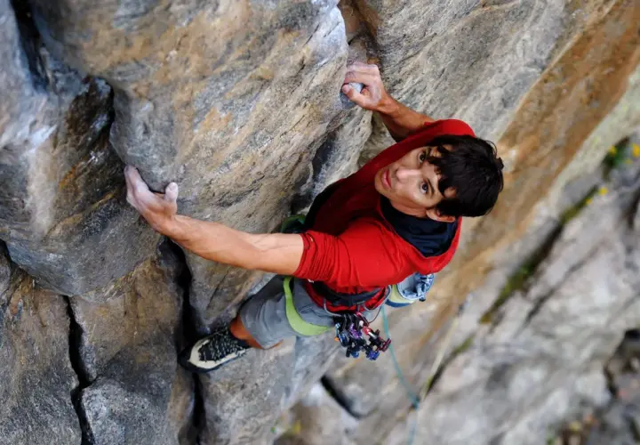 Alex Honnold klettert den El Capitan frei. Sein Blick ist konzentriert, während er sich an den Fels klammert.