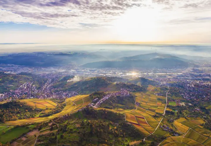 Sonnenuntergang über Stuttgart. Weinberge und Häuser schmiegen sich an die Hügel. Perfekt für eine Wanderung.