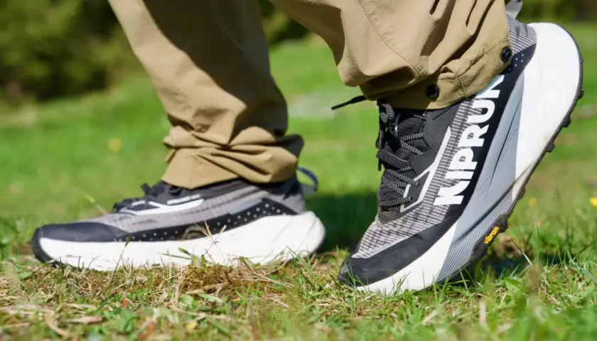 Ein Paar moderne trailrunning schuhe mit grobem Profil auf Gras. Perfekt für jedes Abenteuer.