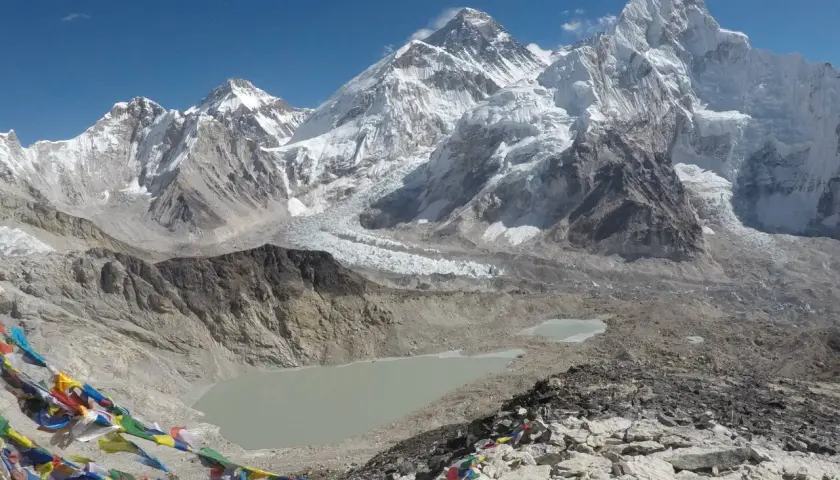 Bunte Gebetsfahnen wehen vor der majestätischen Kulisse des Kala Patthar mit dem Everest im Hintergrund.