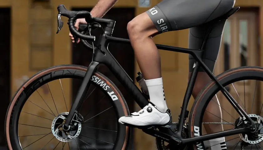 Radfahrer auf einem schwarzen Rennrad, dessen Rahmen aus Carbon gefertigt ist. Das Material Carbon, woraus besteht carbon, ist leicht und stabil.