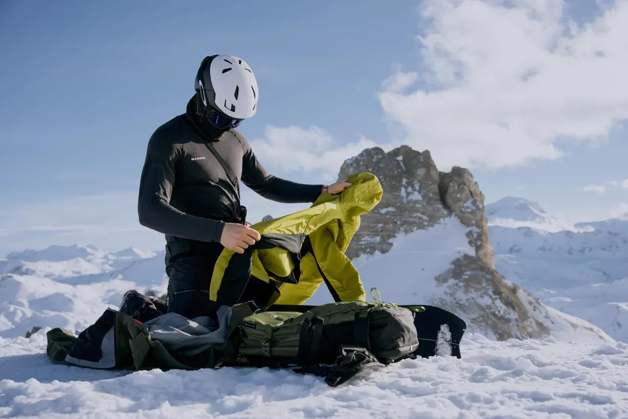 Bergsteiger im Schnee passt sich dem Zwiebelprinzip Kleidung an, um sich vor Kälte zu schützen.