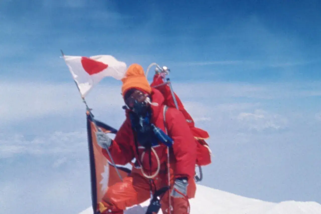 Junko Tabei mit japanischer Flagge auf dem Gipfel des Mount Everest.
