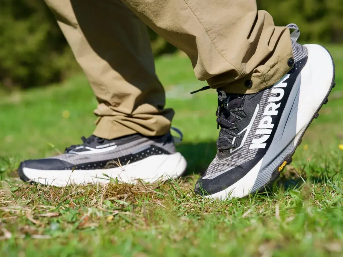 Ein Paar moderne trailrunning schuhe mit grobem Profil auf Gras. Perfekt für jedes Abenteuer.