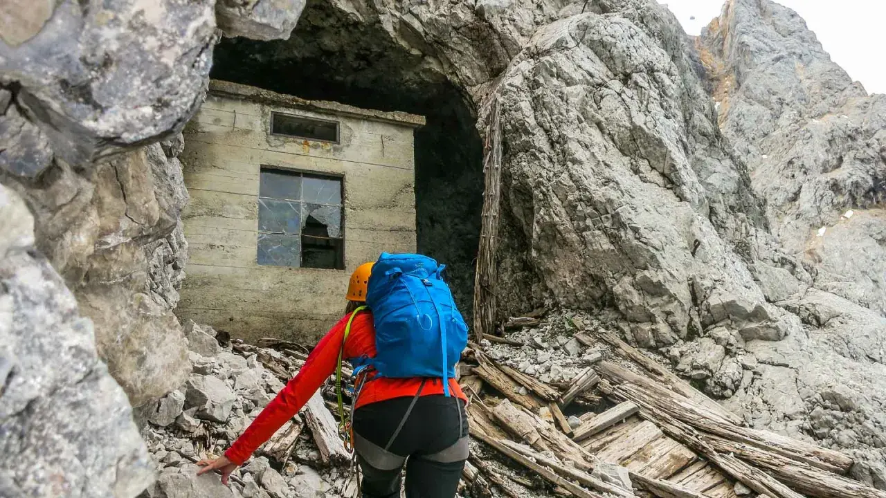 Bergsteigerin nähert sich einer Ruine am Fuße der Zugspitze, die an die Eisenzeit erinnert.
