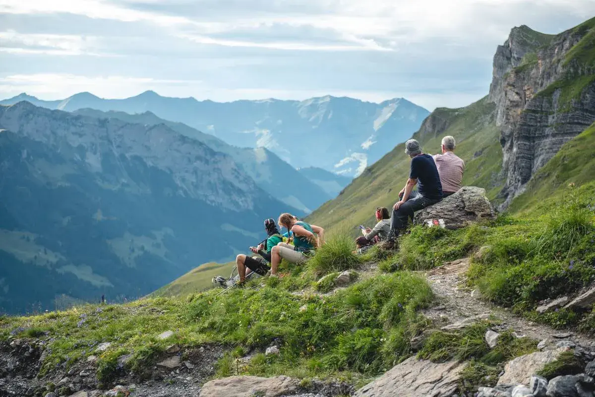 Gruppe genießt die Aussicht beim **Schweiz wandern** in den Bergen.