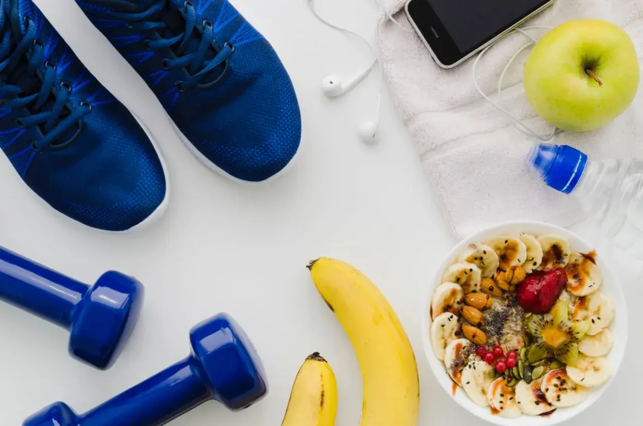 Blaue Laufschuhe, Hanteln, Obstschale, Wasserflasche und Handy – alles bereit für den Halbmarathon Essen.