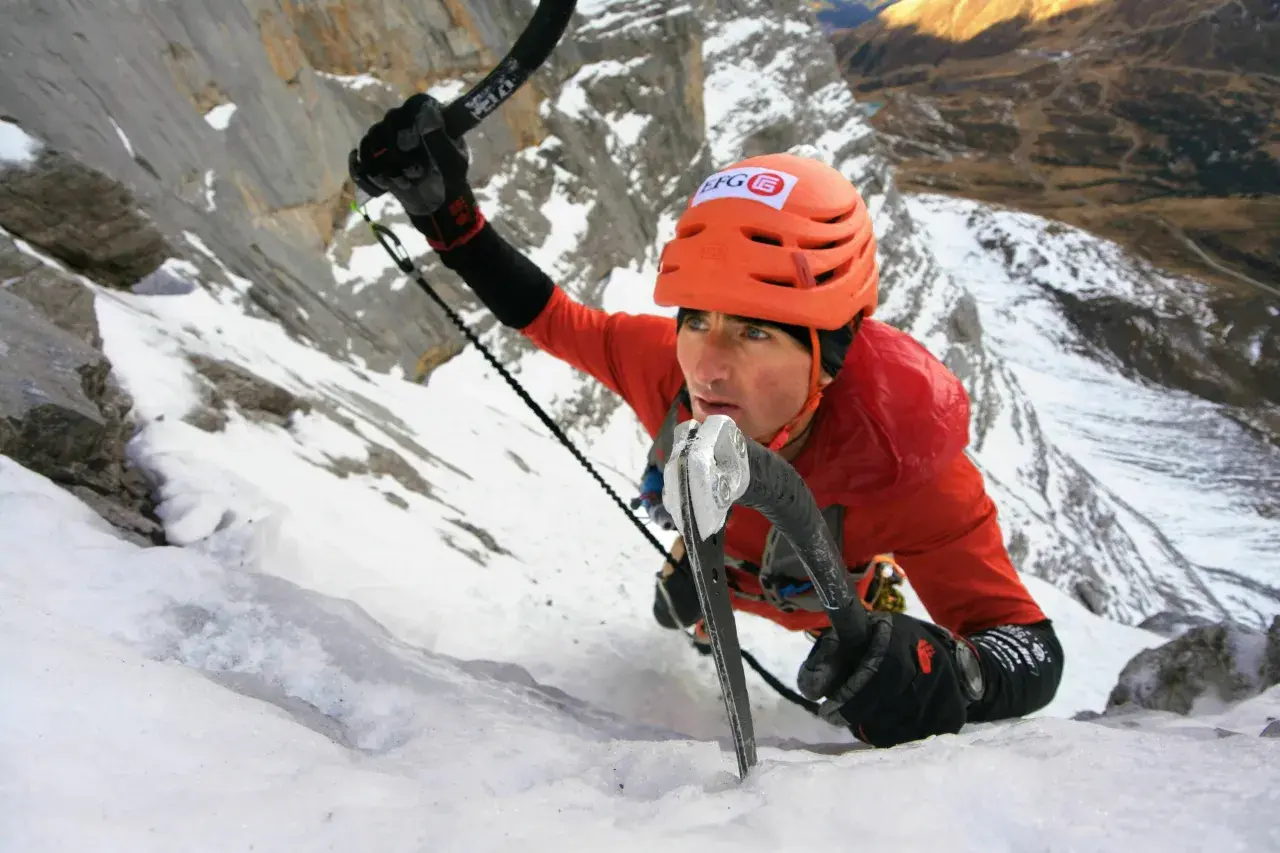 Ueli Steck klettert mit Steigeisen und Eispickel einen eisigen Berghang hinauf.