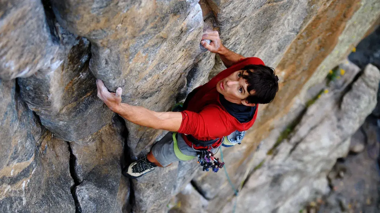 Alex Honnold klettert den El Capitan frei. Sein Blick ist konzentriert, während er sich an den Fels klammert.