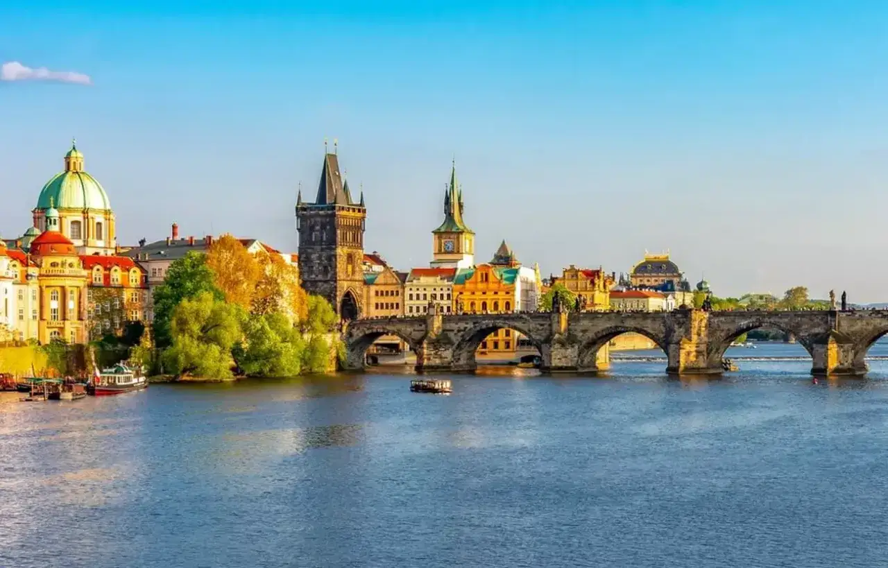 Karlsbr&uuml;cke in Prag, ein Muss f&uuml;r Tschechien Ausflugsziele. Die historische Br&uuml;cke &uuml;berspannt die Moldau, mit T&uuml;rmen und bunten H&auml;usern im Hintergrund.