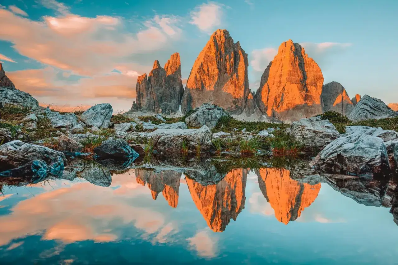 Sonnenuntergang &uuml;ber den Drei Zinnen in den Dolomiten. Ein Spiegelbild der Berge in einem kleinen Bergsee, ideal f&uuml;r fernwanderwege italien.