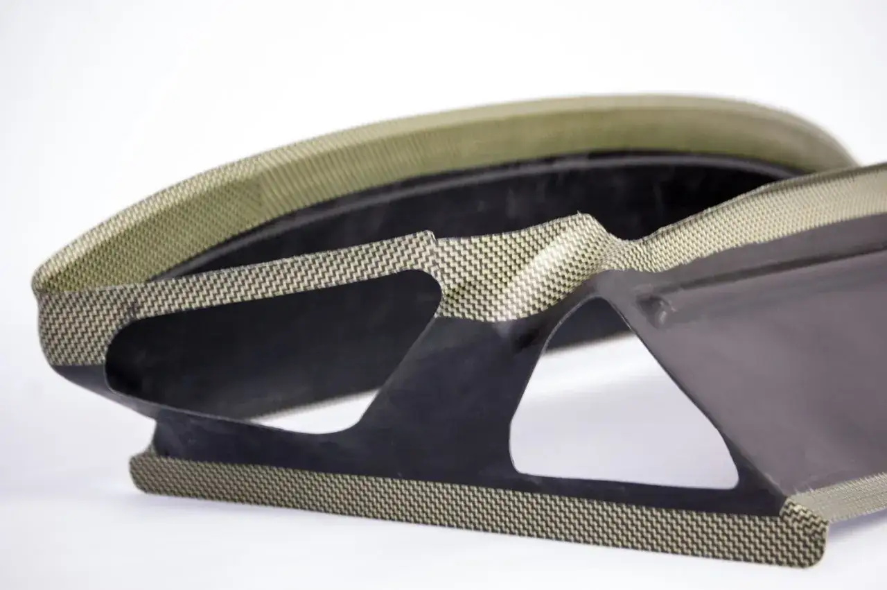 Strukturbauteil aus schwarzem Verbundwerkstoff mit sichtbaren Aramidfasern. Was ist Aramid? Ein extrem starkes und leichtes Material.
