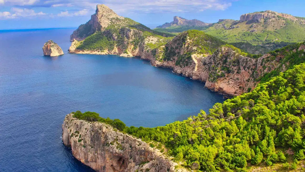 Steile Felsküsten mit Pinienwäldern und türkisfarbenem Meer, ideal für einen fernwanderweg auf Mallorca.