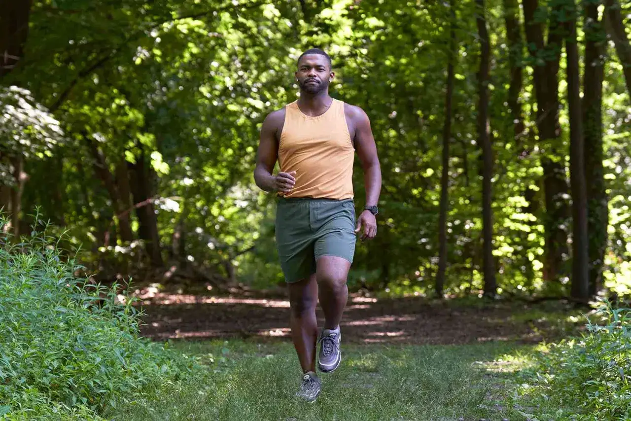 Ein Mann l&auml;uft im Wald, seine Vorbereitung f&uuml;r den Halbmarathon ist in vollem Gange.