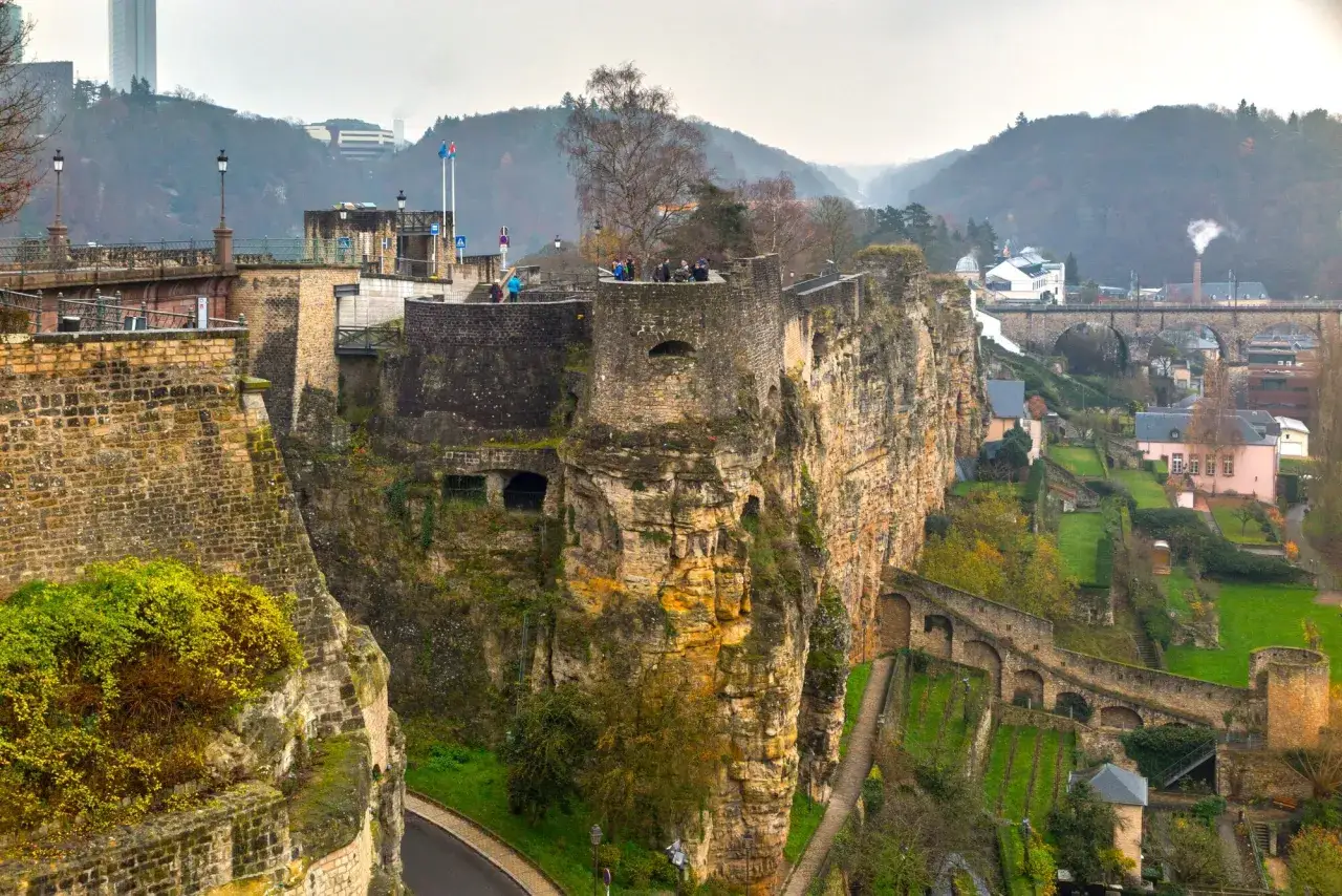 Die Kasematten Luxemburgs thronen auf steilen Felsen, umgeben von gr&uuml;nen H&auml;ngen und historischen Br&uuml;cken.