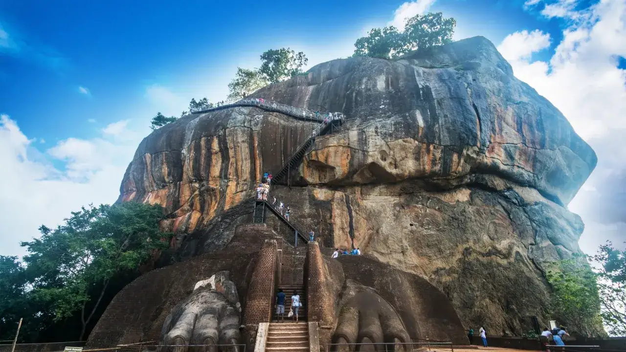 Löwenfelsen in Sri Lanka, eine beeindruckende Felsformation mit einer langen Treppe, die zu ihrer Spitze führt. Besucher erklimmen die Stufen, um die Aussicht zu genießen.
