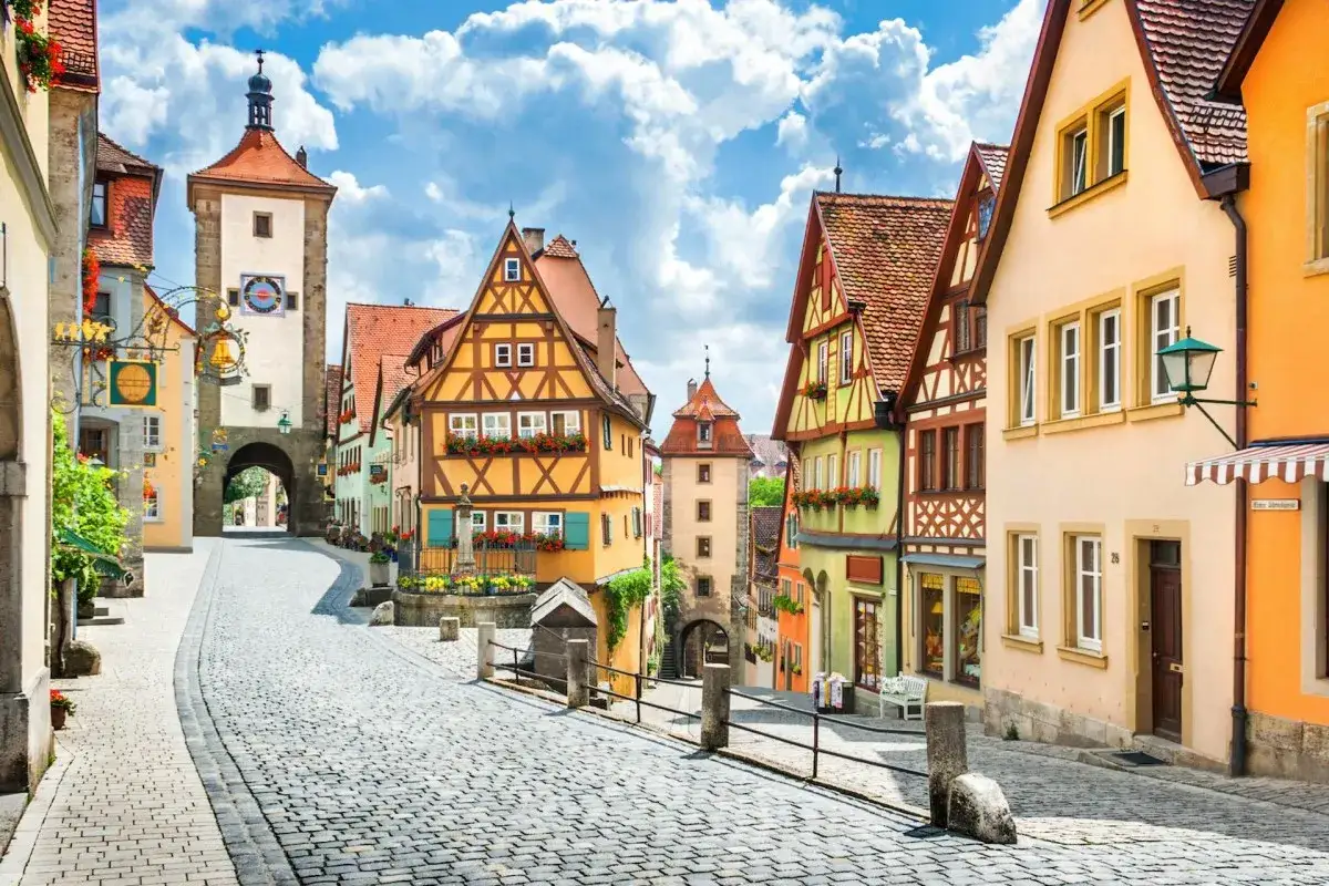 Malerische Gasse in Rothenburg ob der Tauber mit Fachwerkhäusern und einem Stadttor.