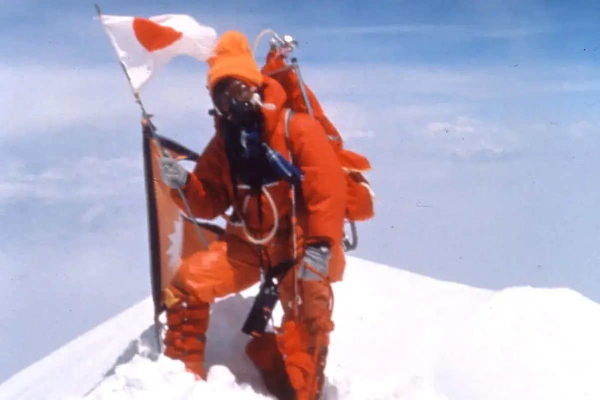 Junko Tabei, die erste Frau auf dem Mount Everest, feiert ihren Triumph auf dem Gipfel mit der japanischen Flagge.