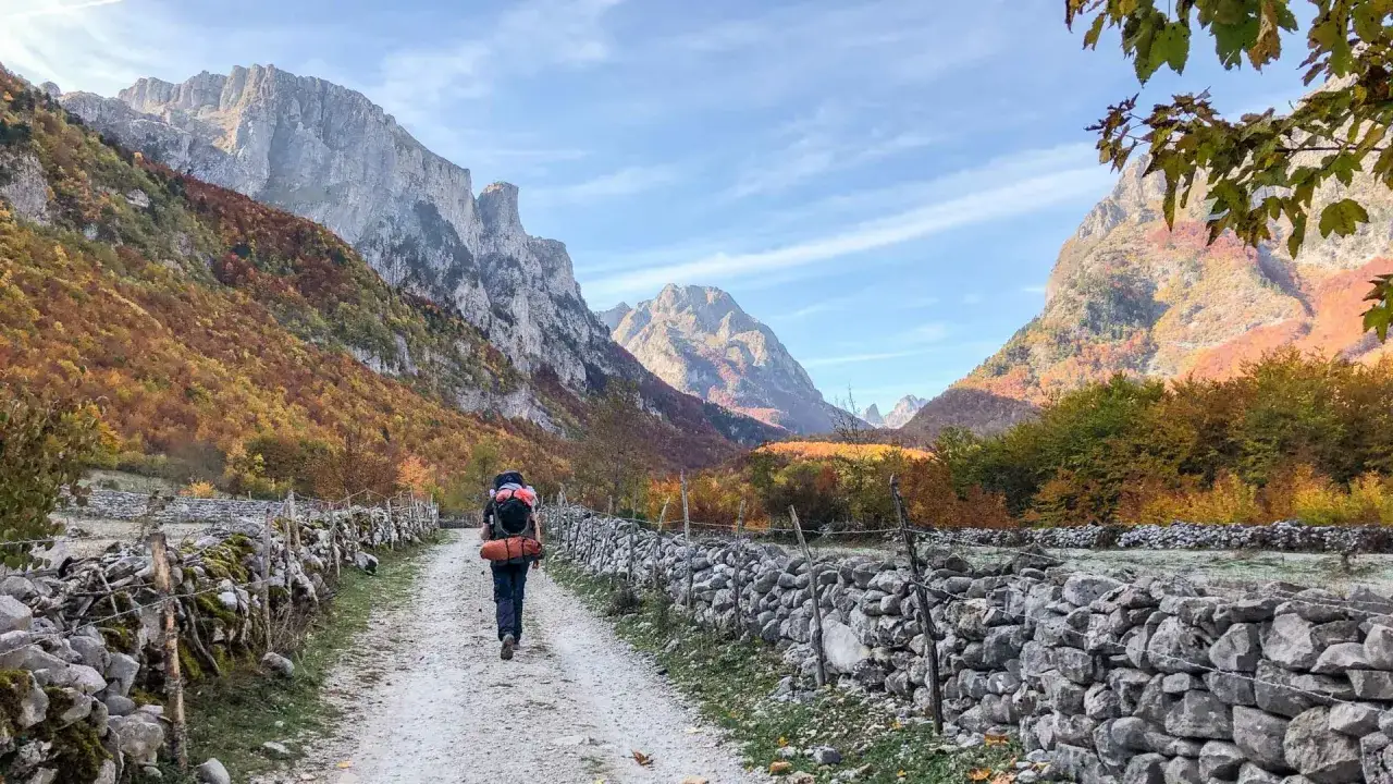 Wanderer auf dem Weg durch die bunten Herbstwälder zu den peaks of the balkans auf eigene faust.