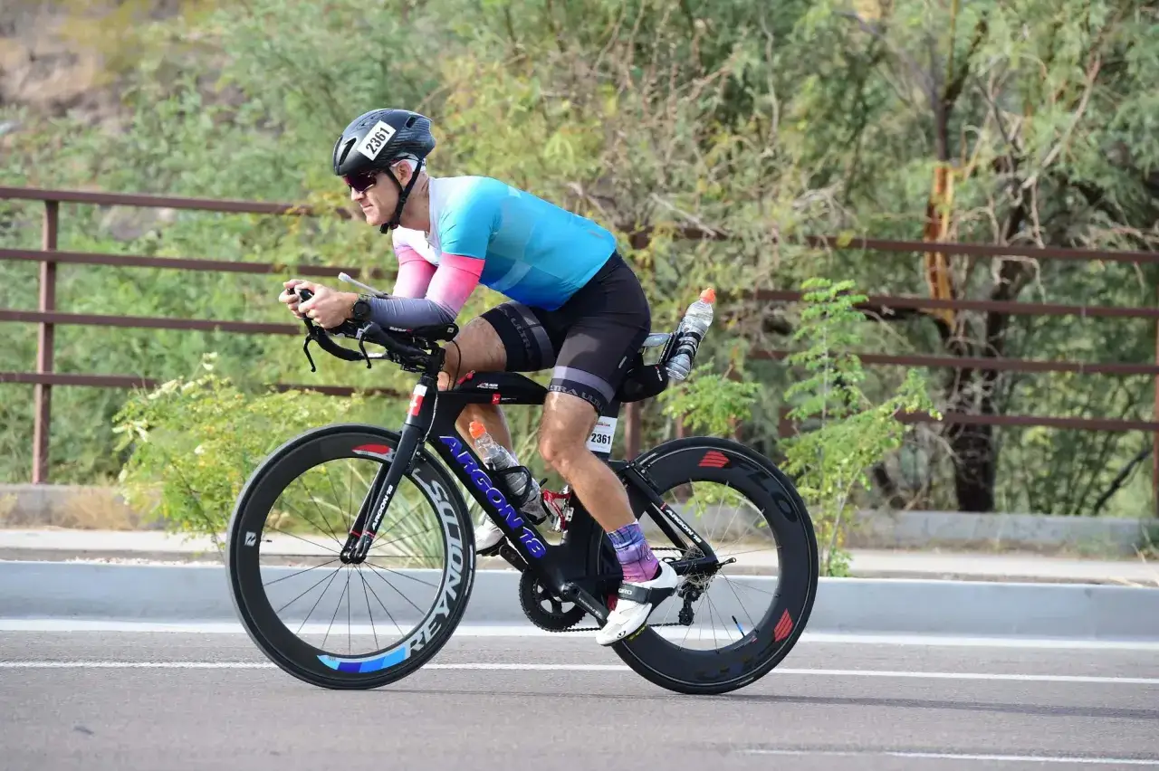 Mann in Triathlon-Kleidung auf einem Rennrad, Nummer 2361. Intensive triathlon vorbereitung auf der Stra&szlig;e.
