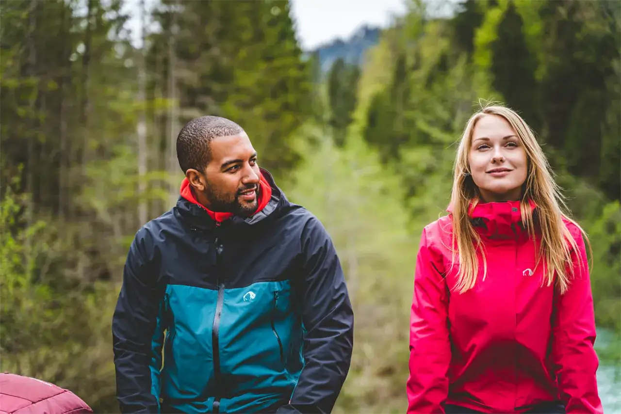 Mann und Frau in bunten Jacken aus modal Stoff, genießen die Natur.