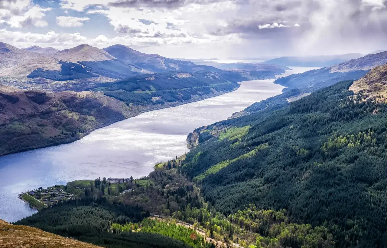 Weite Landschaft mit einem See, bewaldeten H&uuml;geln und Bergen. Perfekt f&uuml;r schottland wandern.