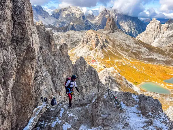 Bergsteiger auf dem Paternkofel Klettersteig, umgeben von majestätischen Dolomiten. Ein Abenteuer mit atemberaubender Aussicht.